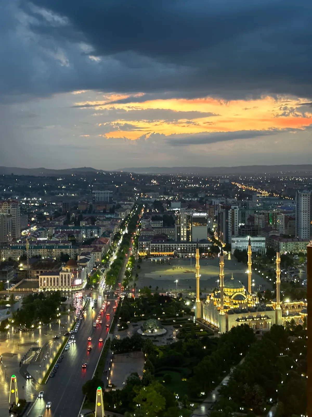 Вечерняя панорама города с освещённой мечетью и четырьмя минаретами