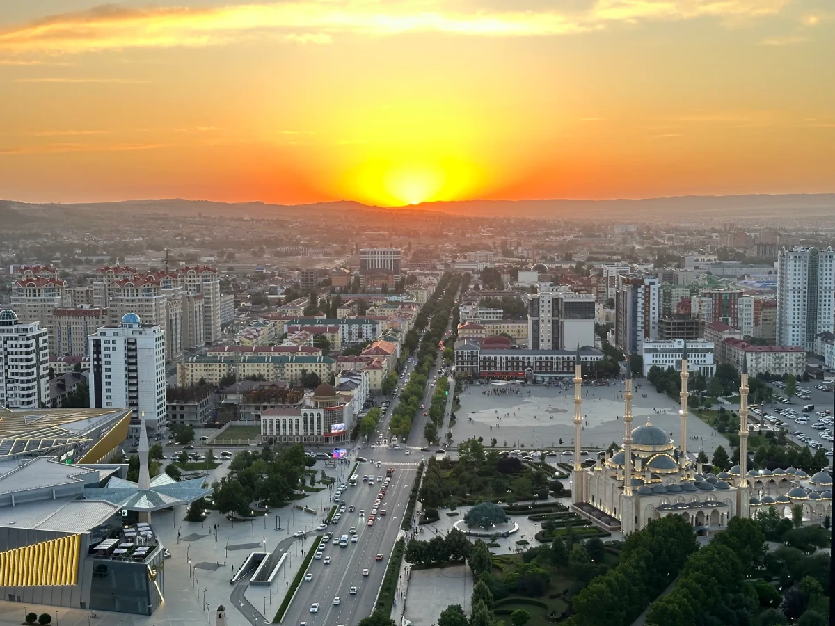 Закатная панорама города, широкой улицы и мечети с четырьмя минаретами