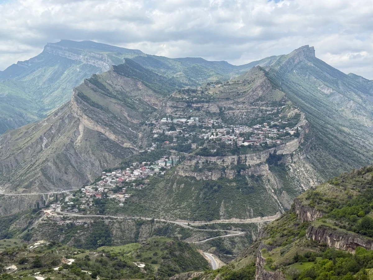 Широкая панорама горного посёлка с ярусами домов и дорог на склоне